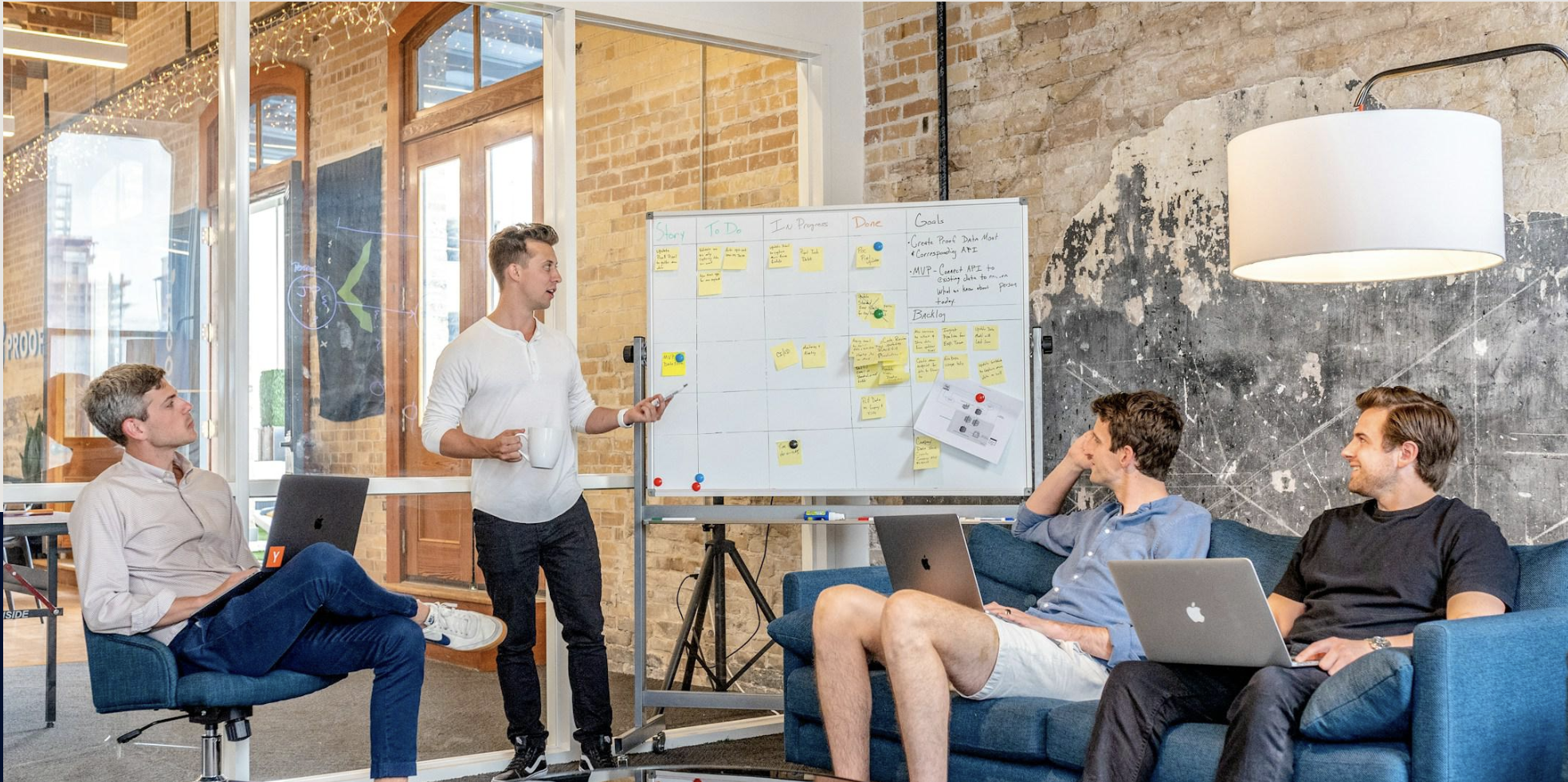 A team working through a plan on a whiteboard in a bright open office.