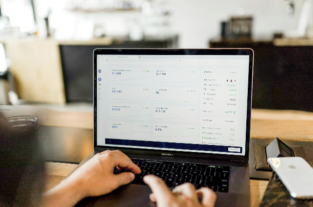A laptop displaying a revenue dashboard with recurring revenue and growth metrics.